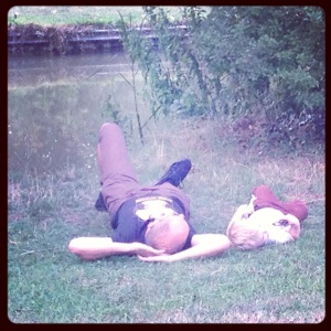 father and son laying down by the canal
